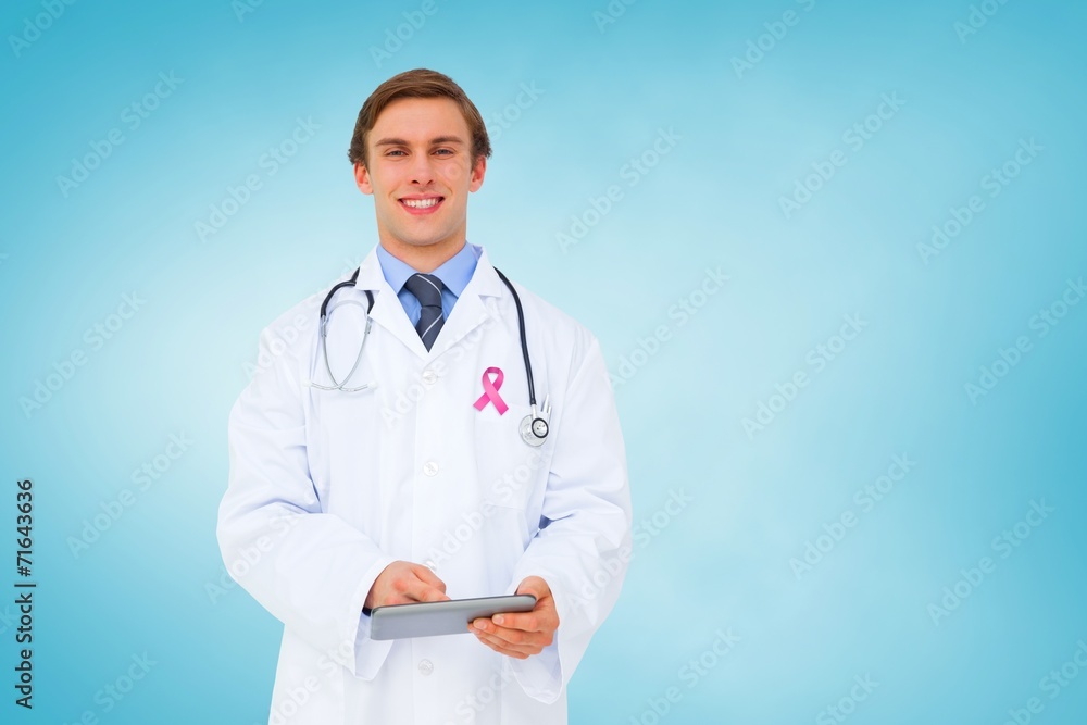 Composite image of young doctor using tablet pc Composite image of young doctor using tablet pc