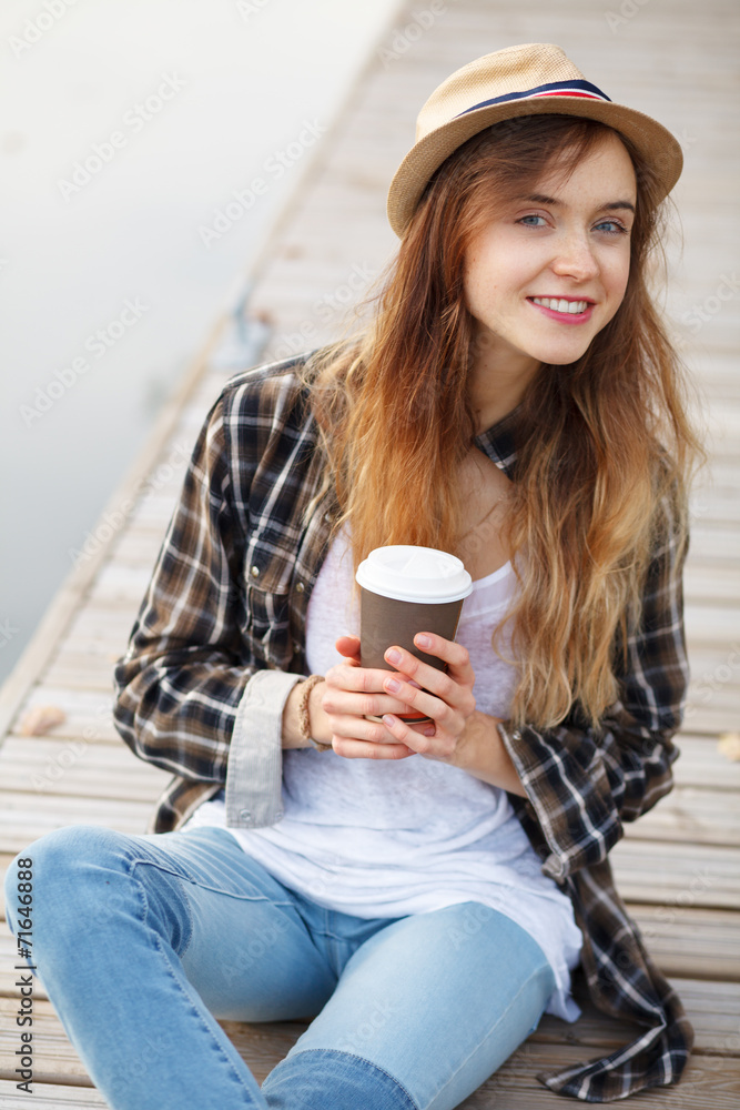 Young beautiful girl sitting on a pier Young beautiful girl sitting on a pier