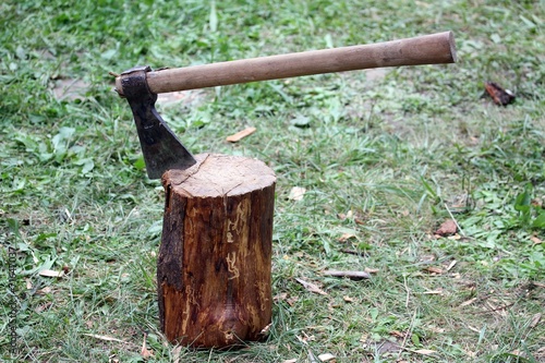 great axe with blade of steel over wood log