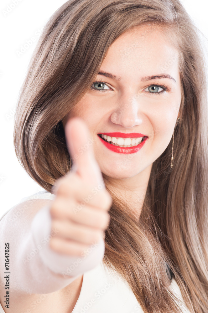 Business woman showing thumbs-up with focus on face. Business woman showing thumbs-up with focus on face.
