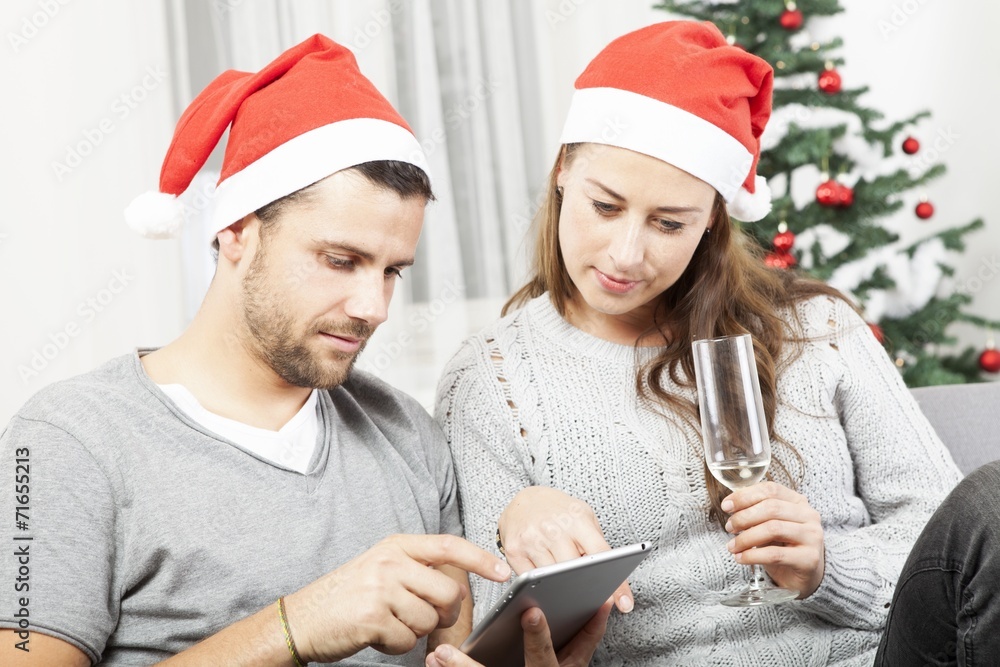 happy young couple use tablet for christmas happy young couple use tablet for christmas