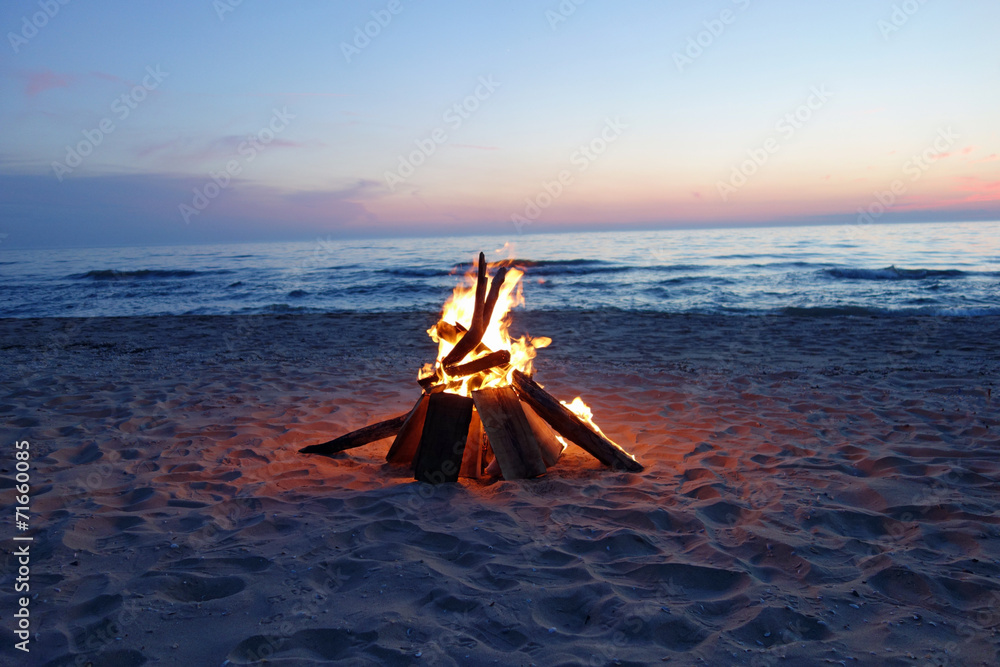 Obraz premium Campfire at dusk by the lake