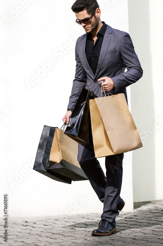 Handsome man in suit with shopping bags