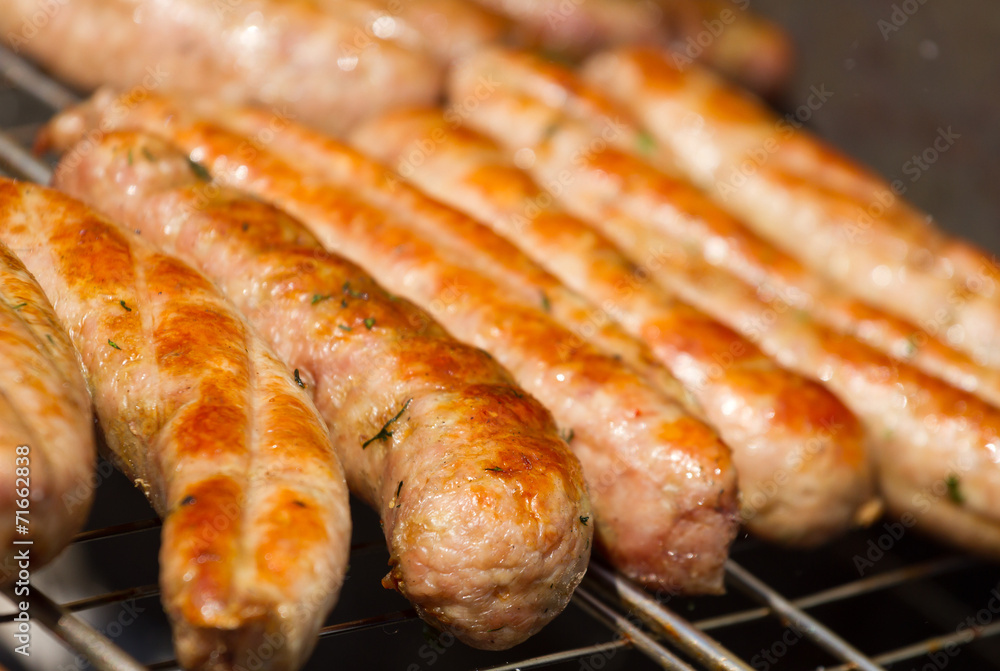 Grilling sausages on barbecue grill