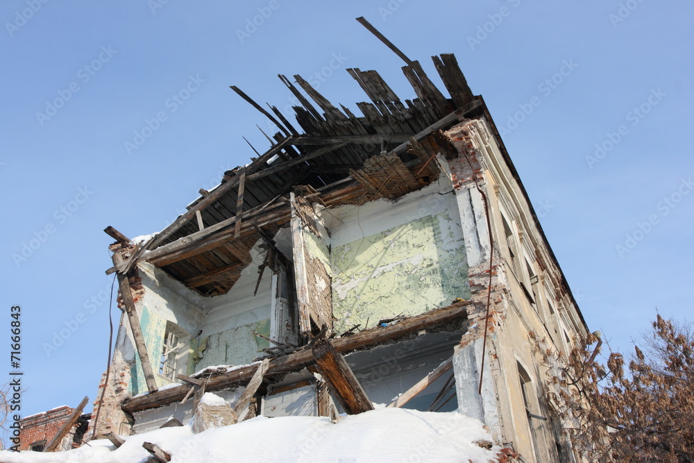 Deserted and a demolished old brick house in the winter city 