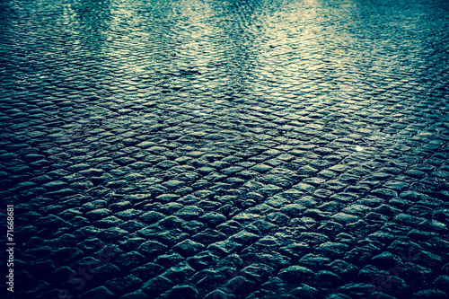 Canvas-taulu Wet cobblestone street at night