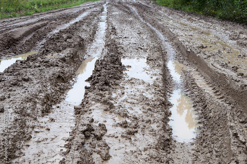 Wheel track on dirt road with puddles