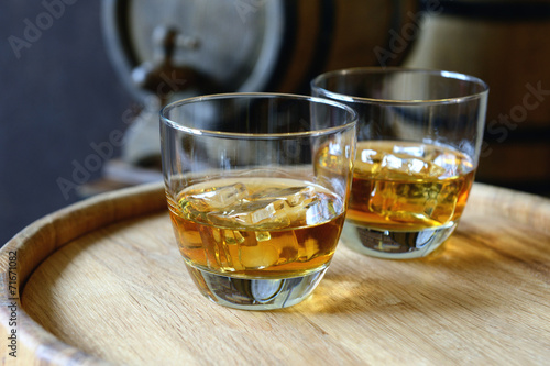 Fototapeta Naklejka Na Ścianę i Meble -  Glasses of brandy in cellar with old barrels