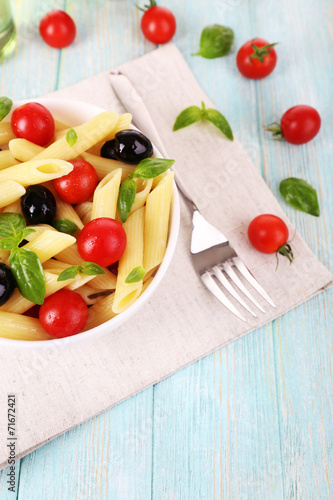 Pasta with tomatoes, olives and basil leaves in bowl