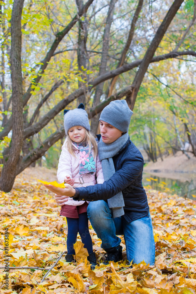 Little girl and dad in autumn park outdoors