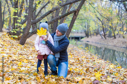 Young father have fun with cute daughter in autumn park