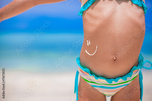 Canvas Print Closeup smile painted by sun cream on little girl stomach