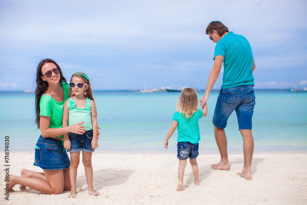 Family of four walking by the sea and enjoy beach vacation