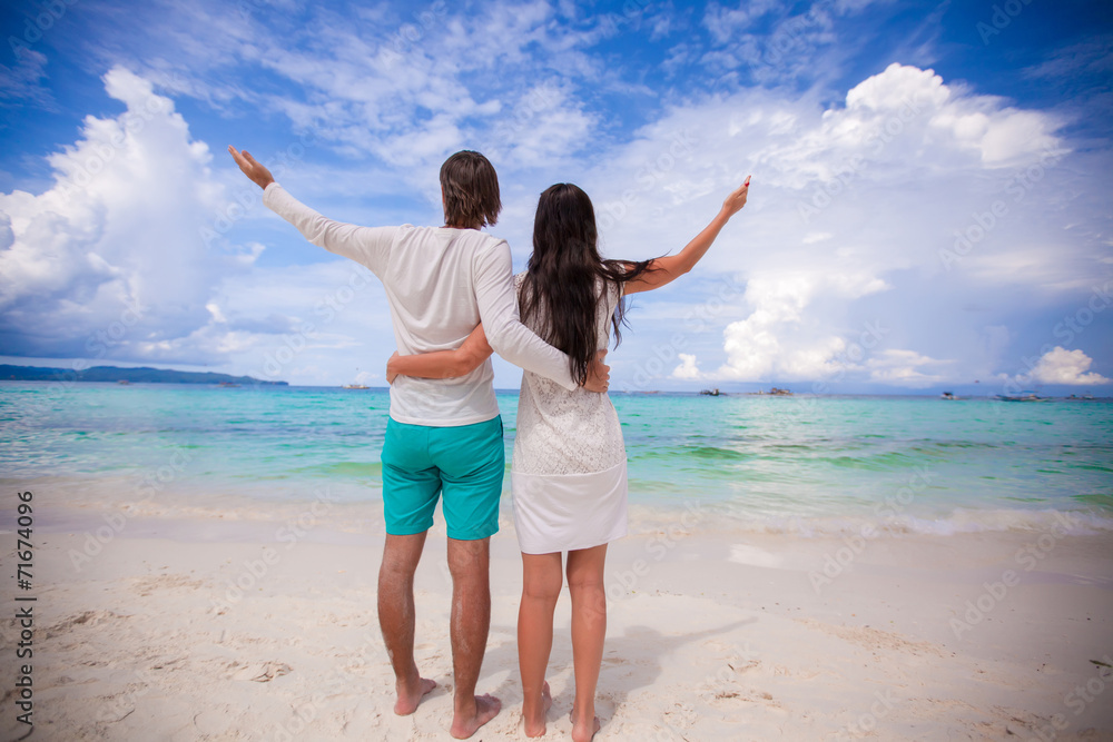Back view of young couple on white beach Back view of young couple on white beach