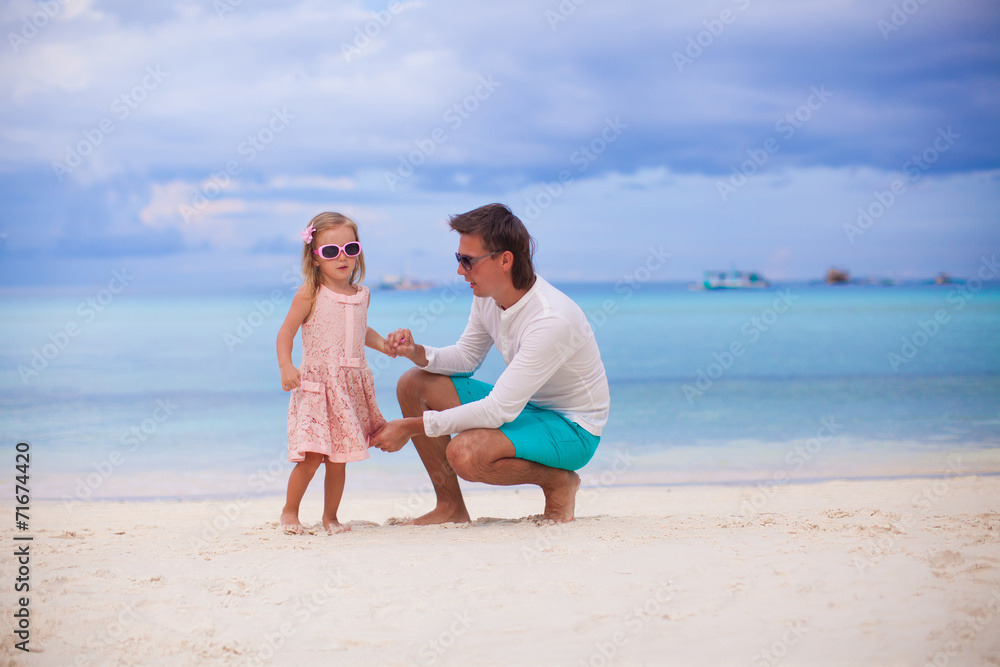 Happy dad and his adorable little daughter at white sandy beach Happy dad and his adorable little daughter at white sandy beach