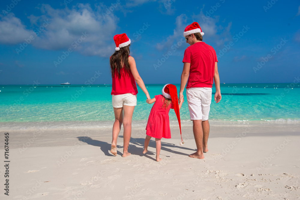 Happy family in Christmas Hats having fun on white beach Happy family in Christmas Hats having fun on white beach