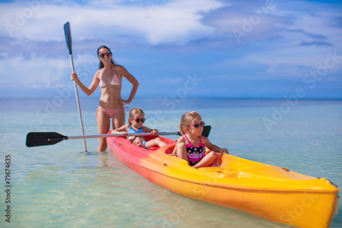 Young mother and two her little daughters kayaking at tropical © travnikovstudio