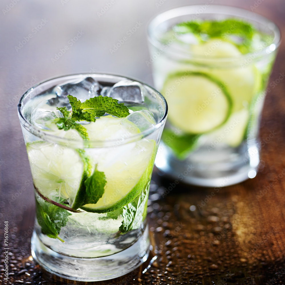 Fototapeta premium two ice cold fresh mojito cocktails on wooden table