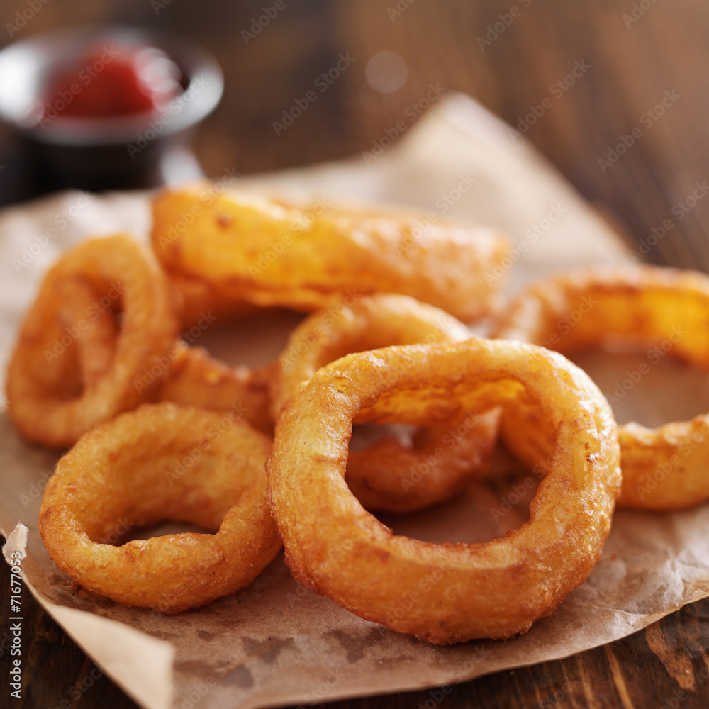 crispy onion rings with ketchup on parchment paper