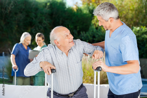 Male And Female Caretakers Helping Elderly People © Tyler Olson