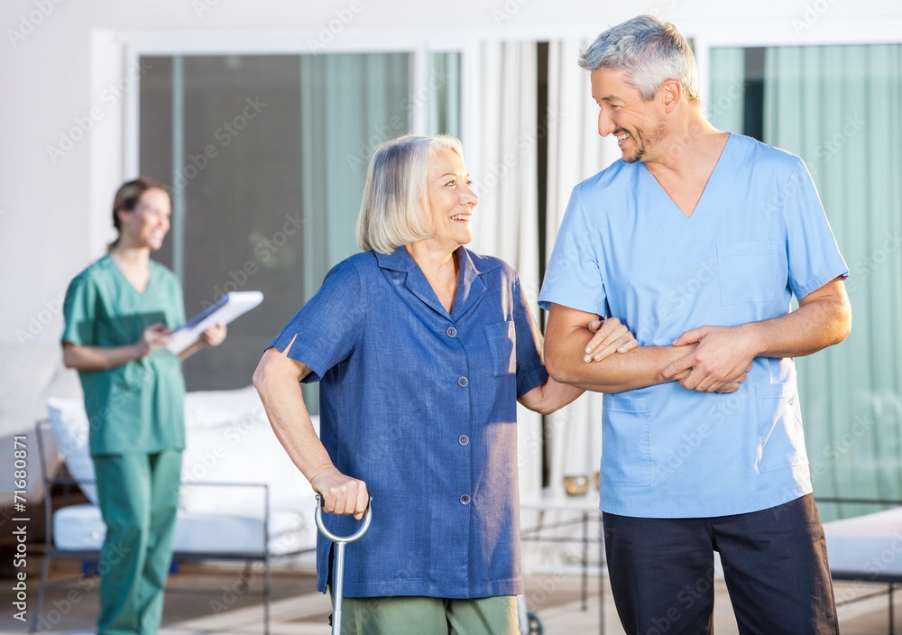 Happy Nurse Assisting Senior Woman To Walk Happy Nurse Assisting Senior Woman To Walk