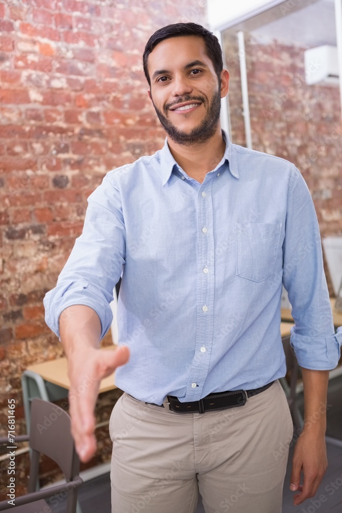Smiling businessman offering handshake at office Smiling businessman offering handshake at office
