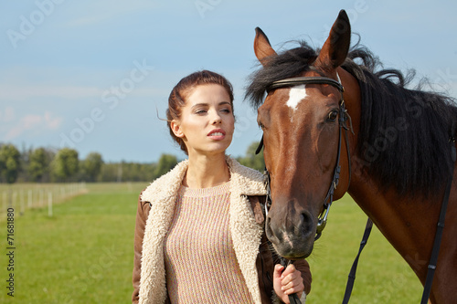 An attractive young woman with a horse