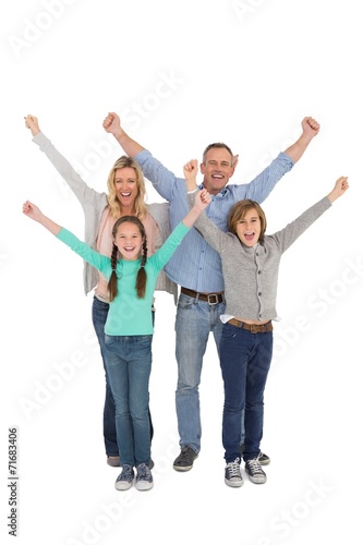Smiling family raising their arms