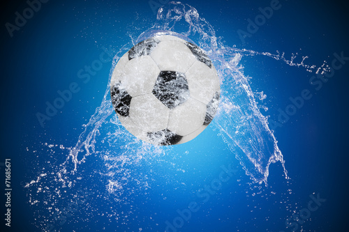 Sport ball with water splash on black background