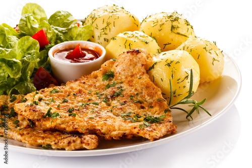 Fried pork chop, boiled potatoes and vegetable salad