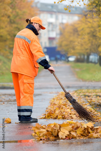 Obraz na plátně Street sweeper cleaning city pavement from dead leaves