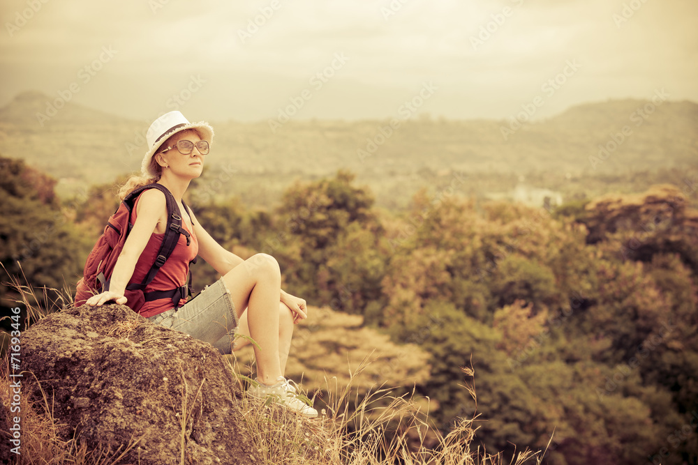 tourist with backpack relaxing on rock and enjoying admiring the tourist with backpack relaxing on rock and enjoying admiring the
