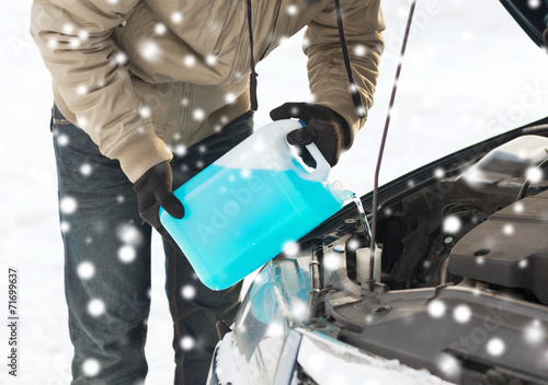 closeup of man pouring antifreeze into car photo