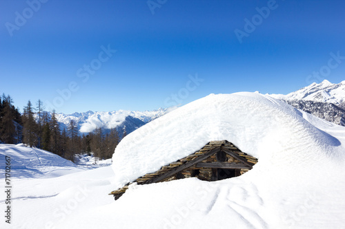 Casa innevata in montagna