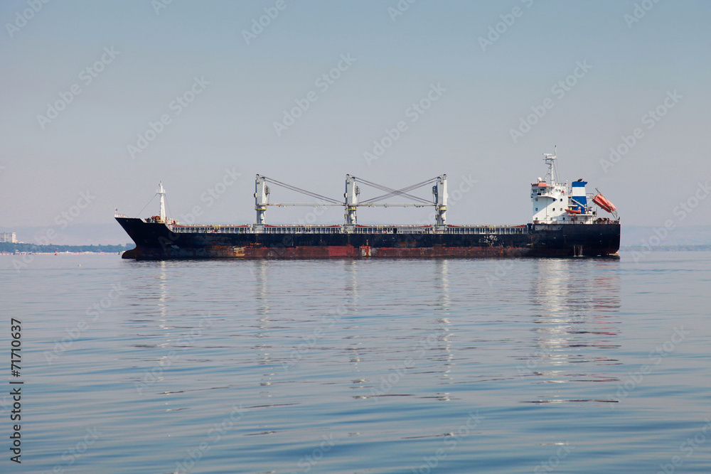 Industrial cargo ship goes on still sea