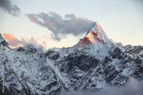 First rays of the rising sun on the top of Ama Dablam peak