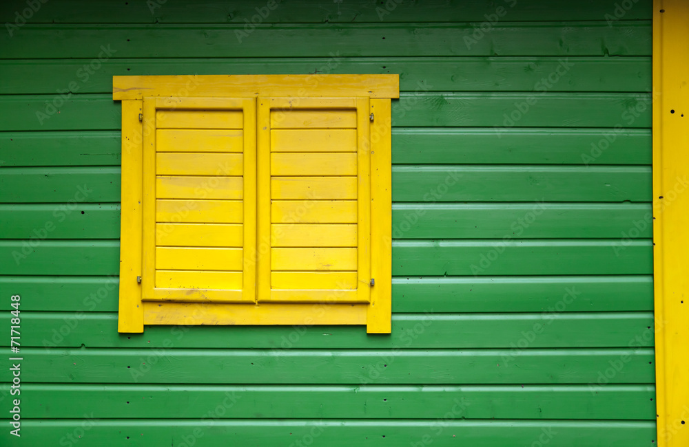 Texture of bright painted wooden wall with yellow closed window Texture of bright painted wooden wall with yellow closed window