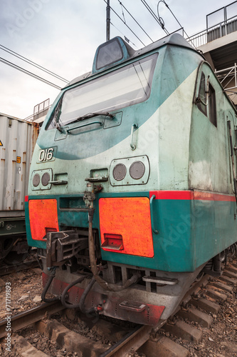 Modern green cargo train locomotive with red signs