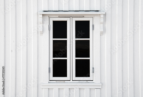 Window in white wooden wall. Norway architecture