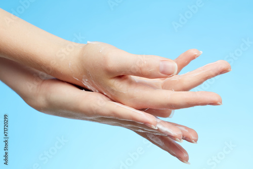 Woman's hands in moisturizer cream © Nik_Merkulov
