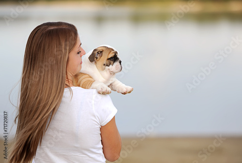 the young woman holds on hands of a puppy of breed the boxer and © Irina84