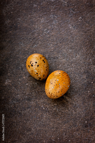 Colored quail eggs on a brown surface