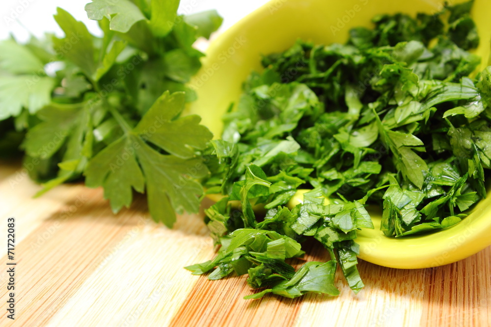 Fresh, natural and chopped parsley on wooden cutting board Fresh, natural and chopped parsley on wooden cutting board