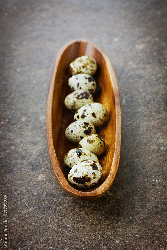 Quail eggs in a wooden cup on a vintage surface Quail eggs in a wooden cup on a vintage surface