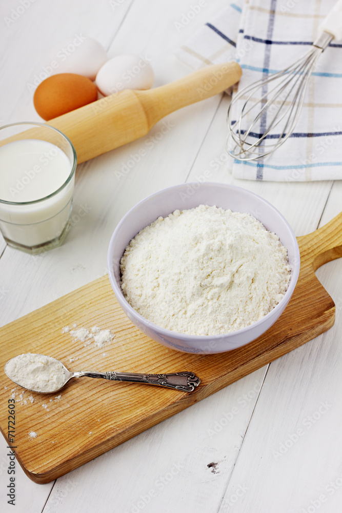 Flour in ceramic bowl with eggs and rolling pin Flour in ceramic bowl with eggs and rolling pin
