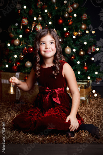 Beautiful little girl ringing the bell at Christmas