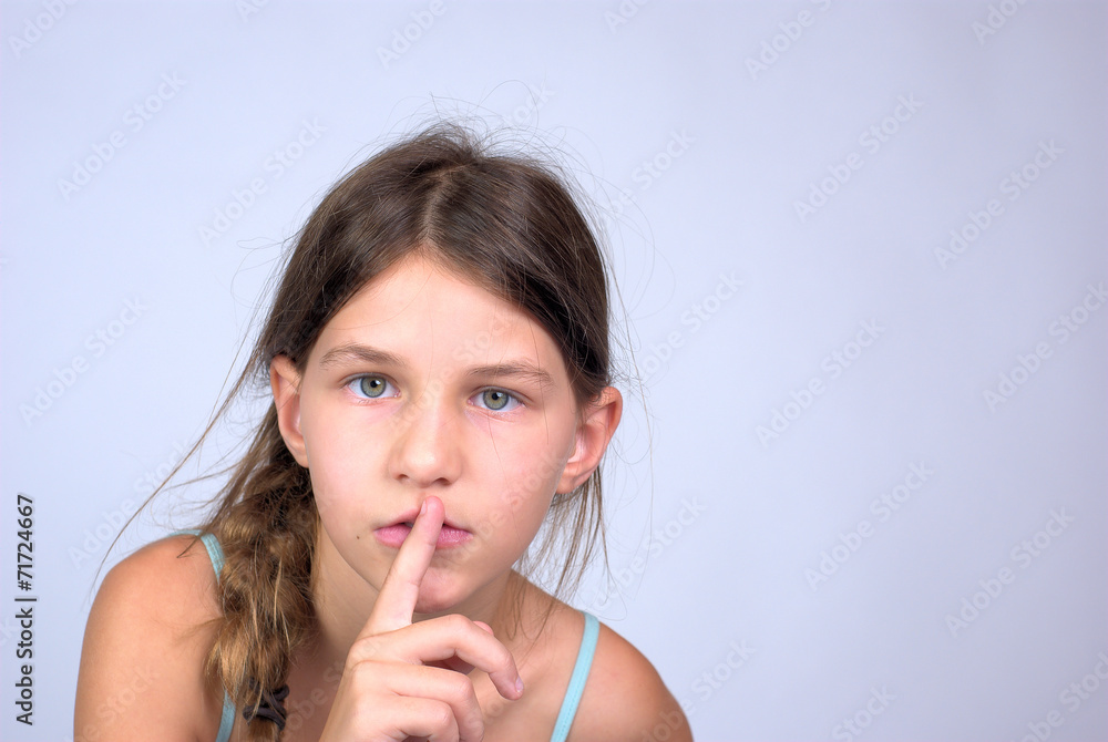 Young girl with finger on lips shushing Young girl with finger on lips shushing