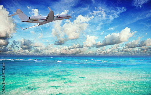 Private jet over the tropical sea