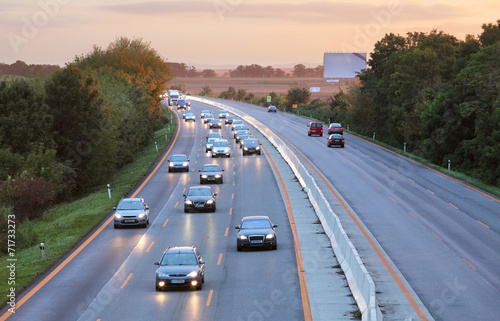 Cars on highway road at sunset