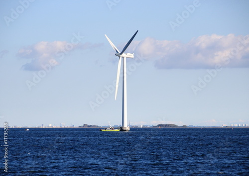 Ocean windmill in rough sea with inspection ship